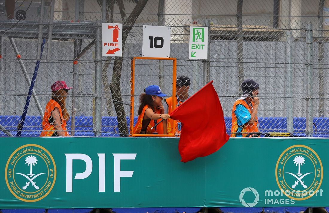 Un comisario agita la bandera roja
