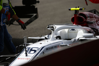 Marshals remove the damaged car of Charles Leclerc, Sauber C37, after a crash on the opening lap