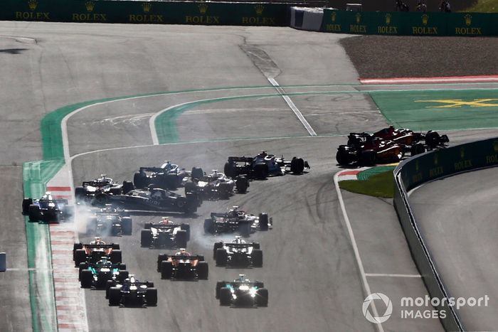 Charles Leclerc, Ferrari F1-75, Carlos Sainz, Ferrari F1-75, George Russell, Mercedes W13, el resto a través de la primera curva mientras Pierre Gasly, AlphaTauri AT03, entra en un trompo