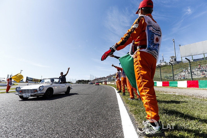 Marshals line the track as Stoffel Vandoorne, McLaren, passes in the drivers parade