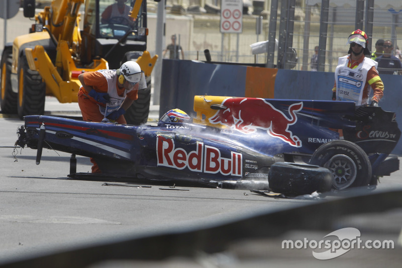 Oficiales de pista retiran el averiado coche de Mark Webber, Red Bull Racing