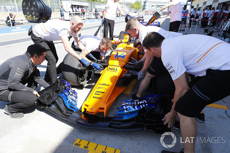 Mechanics work on the Fernando Alonso McLaren MCL33 in the pit lane