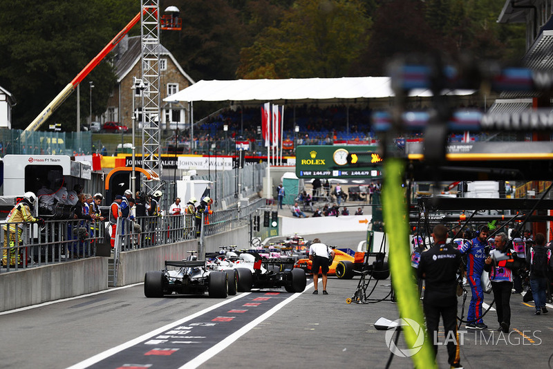 Valtteri Bottas, Mercedes AMG F1 W09, Kevin Magnussen, Haas F1 Team VF-18, Romain Grosjean, Haas F1 Team VF-18, and Brendon Hartley, Toro Rosso STR13, form the rear of a queue of cars in the pit lane, as FP3 is restarted following a red flag incident for a crash involving Stoffel Vandoorne, McLaren MCL33. Photographer Romano Poli can be seen on the right