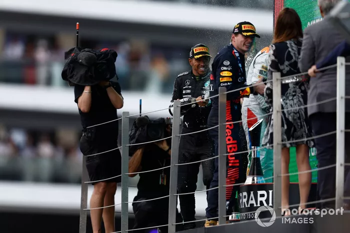 Lewis Hamilton, Mercedes-AMG, 3ª posición, Max Verstappen, Red Bull Racing, 1ª posición, rocía Champán en el podio.
