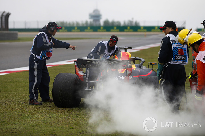 Marshals bergen de rokende auto van Daniel Ricciardo, Red Bull Racing RB14 Tag Heuer, na een motorpr