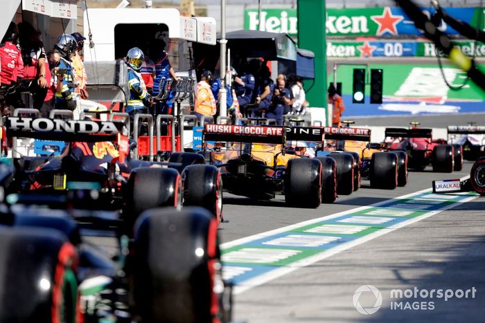 Daniel Ricciardo, McLaren MCL35M, y Sergio Pérez, Red Bull Racing RB16B, fila del pit lane
