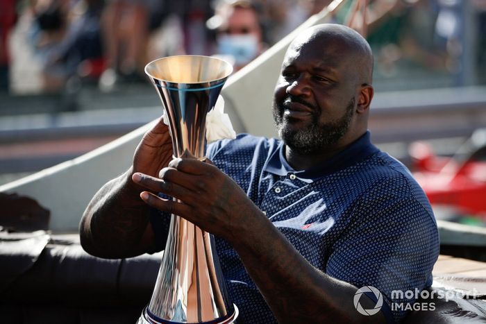 La ex estrella del baloncesto Shaquille O'Neal llega a la ceremonia del podio con el trofeo