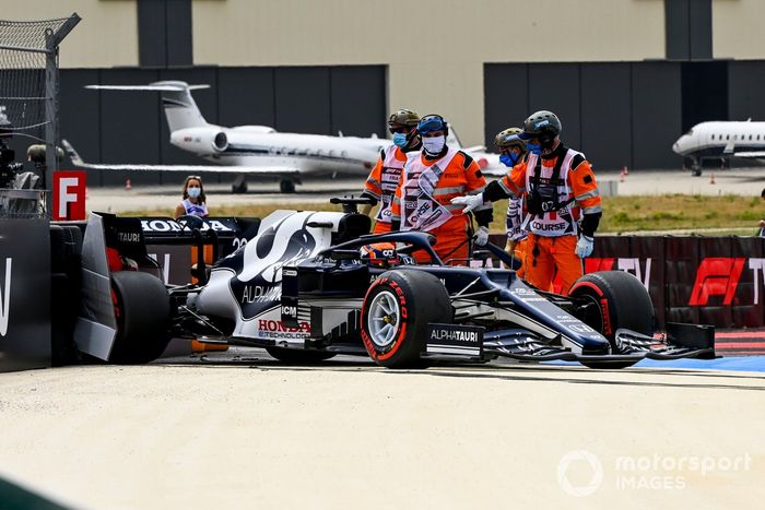 Los comisarios de pista asisten a Yuki Tsunoda, AlphaTauri AT02, después de chocar 