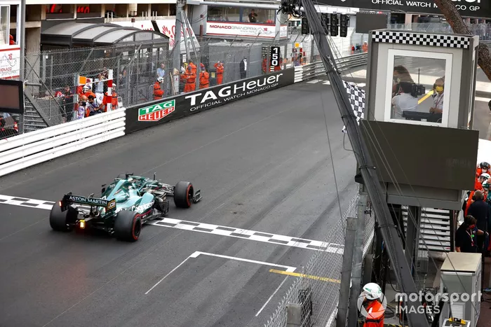 Lance Stroll, Aston Martin AMR21, cruza la línea de meta mientras ondea la bandera a cuadros Estrella del tenis por Serena Williams