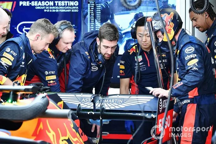 Red Bull team members examine the rear of a Red Bull Racing RB16