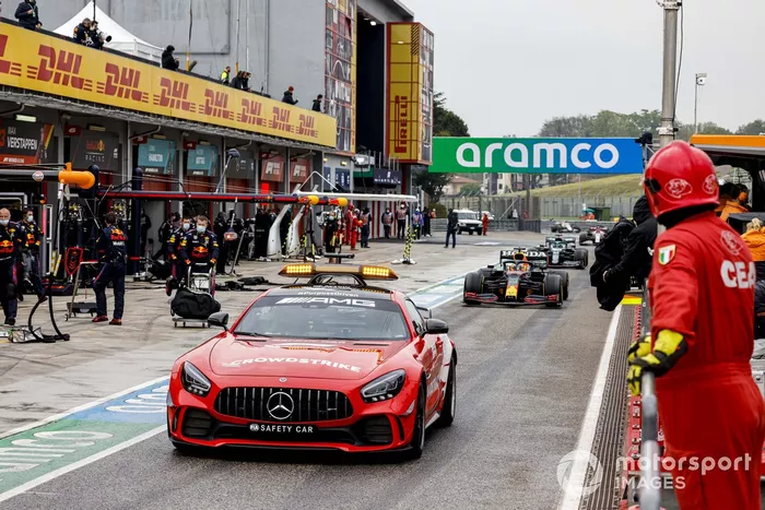 El Safety Car lidera a Max Verstappen, Red Bull Racing RB16B, Lance Stroll, Aston Martin AMR21, y el resto del campo en los pits