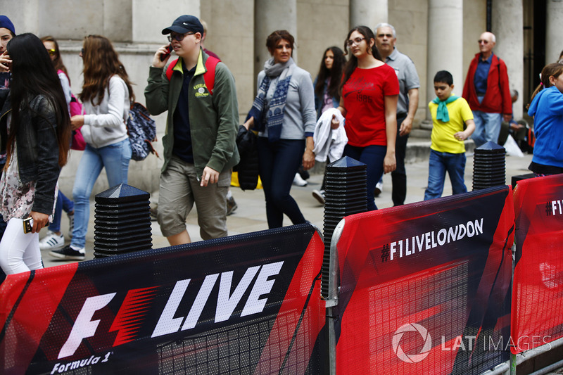 Los miembros del público a pie pasando barandas cubiertas de F1 Londres