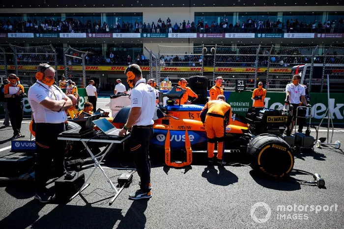 Mecánicos e ingenieros preparan el coche de Lando Norris, McLaren MCL35M, en la parrilla de salida