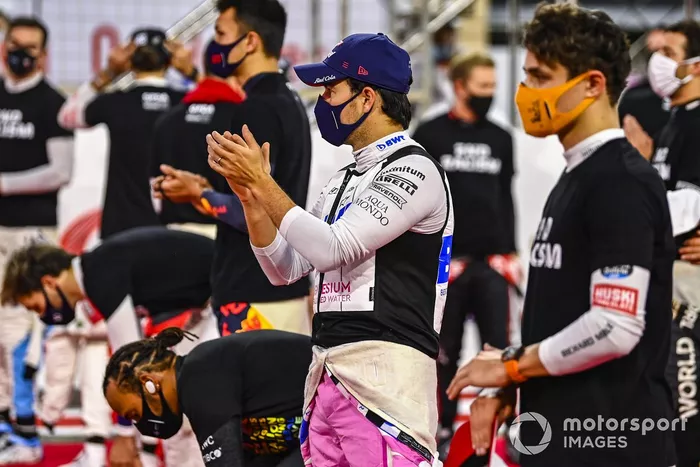 Sergio Perez, Racing Point, y el otro piloto se paran y se arrodillan para apoyar la campaña 