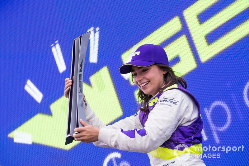 Jamie Chadwick celebrates on the podium with the trophy