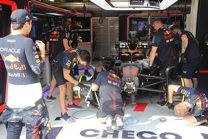 Sergio Pérez, Red Bull Racing observa al equipo reparando su coche 