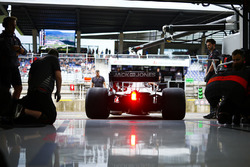 Haas mechanics watch Kevin Magnussen, Haas F1 Team VF-18, exit the team's garage