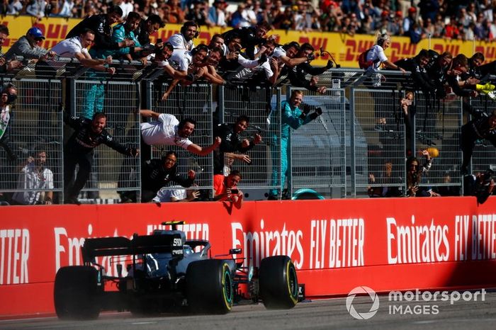 Valtteri Bottas, Mercedes AMG W10, 1ª posición, pasa a su equipo mientras celebran en el pit wall después de coger la bandera a cuadros