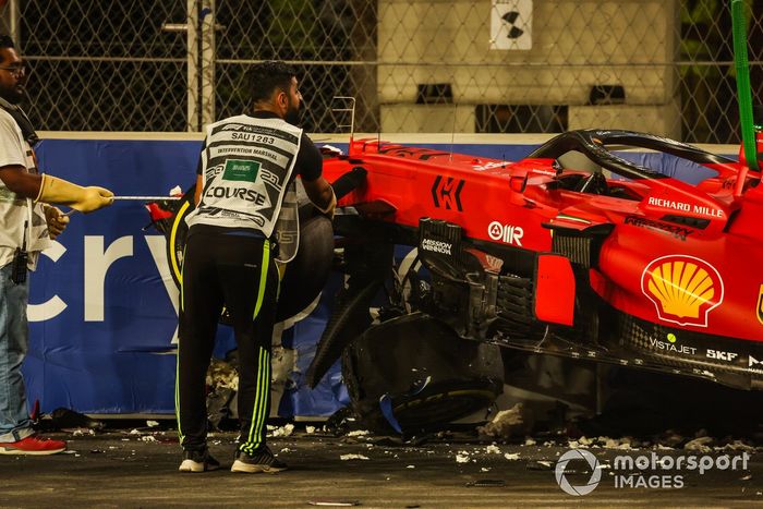 Los oficiales de pista retiran el coche de Charles Leclerc, Ferrari SF21, del circuito