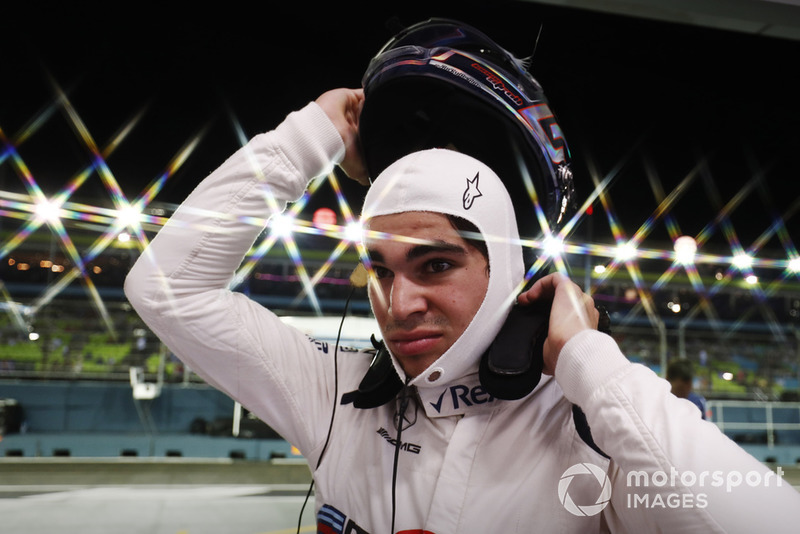 Lance Stroll, Williams Racing puts on his helmet in the pit lane