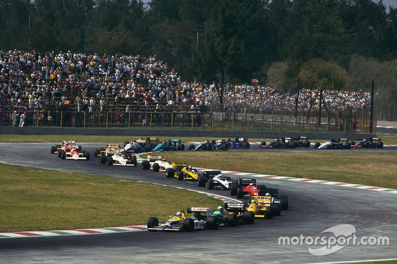 Nigel Mansell, Williams FW11B Honda, lidera a Teo Fabi, Benetton B187 Ford, Ayrton Senna, Lotus 99T Honda, y el resto del grupo en la primera vuelta