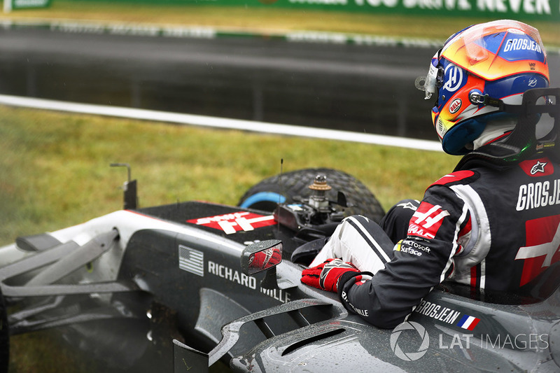 Romain Grosjean, Haas F1 Team VF-17 climbs from his car after crashing