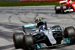 Valtteri Bottas, Mercedes AMG F1 W08, raises an arm in victory celebration at the finish, ahead of Sebastian Vettel, Ferrari SF70H