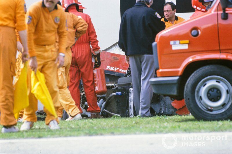 Los oficiales asisten al Ferrari 640 de Gerhard Berger después de un accidente