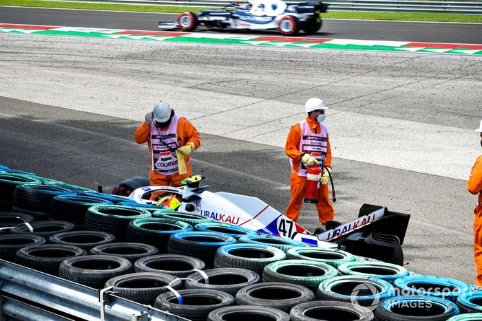 Los oficiales de pista asisten a Mick Schumacher, Haas VF-21, tras su accidente en la FP3