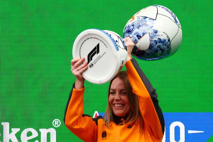 Laura Bowden, Chief Financial Officer at McLaren lifts the Constructors trophy on the podium