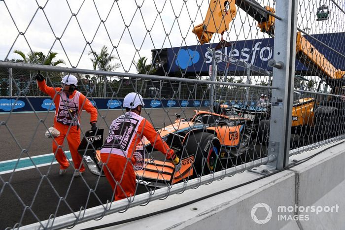 Los oficiales de pista retiran el coche dañado de Lando Norris, McLaren MCL36, del circuito