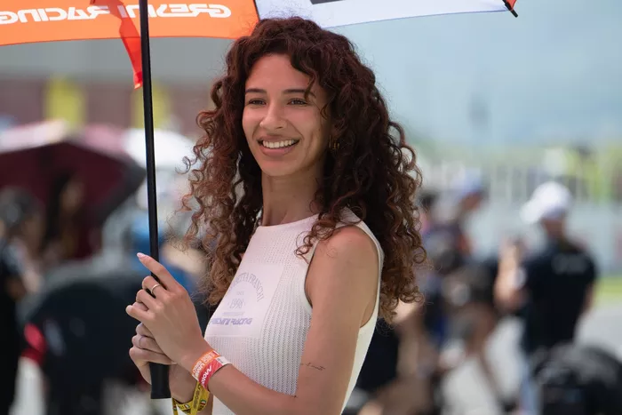 A grid girl poses on the grid.