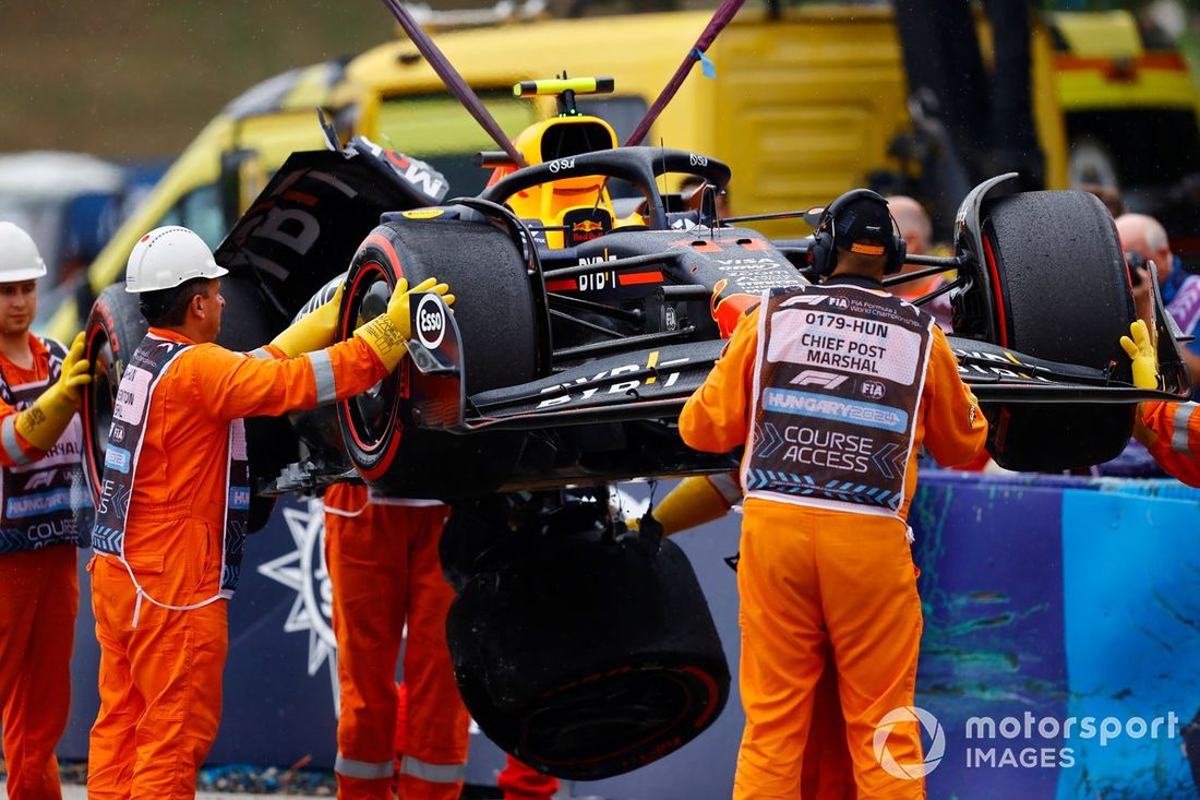 Los comisarios retiran el coche dañado de Sergio Pérez, Red Bull Racing RB20
