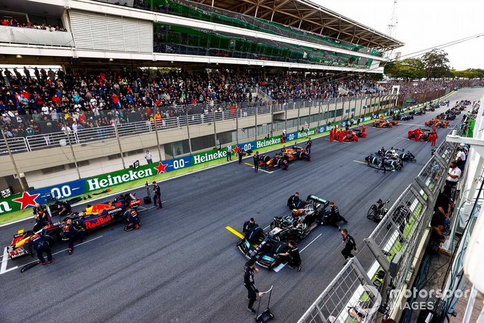 Los mecánicos realizan los últimos preparativos en la parrilla antes de la salida