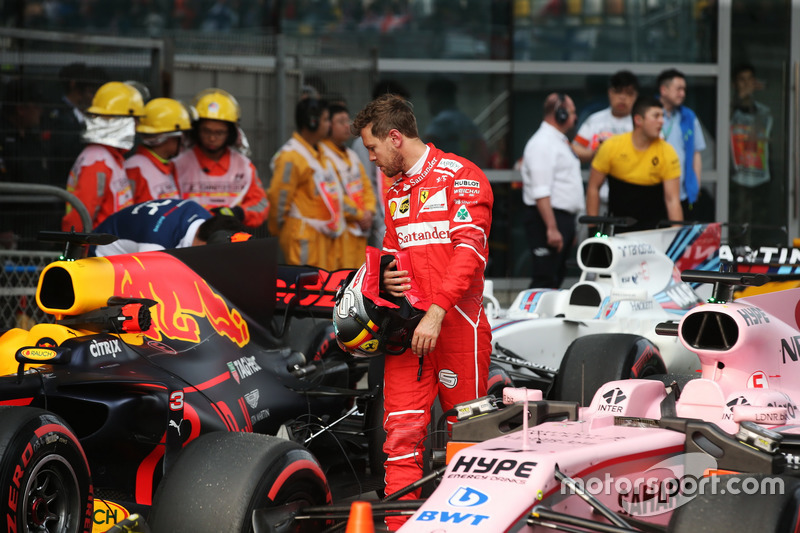 Sebastian Vettel, Ferrari, examines a Red Bull Racing RB13 in parc ferme