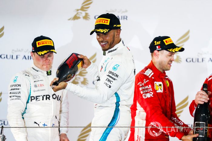 Valtteri Bottas, Mercedes AMG F1, 2° classificato, Lewis Hamilton, Mercedes AMG F1, 3° classificato, e Sebastian Vettel, Ferrari, 1° classificato, spruzzano il Waard, il sostitutivo non alcolico dello Champagne, sul podio