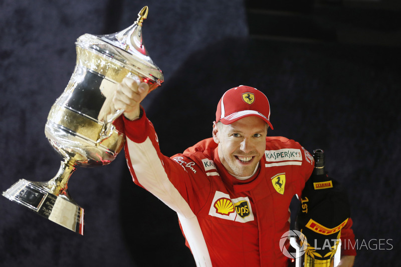 Sebastian Vettel, Ferrari, vainqueur, lève son trophée sur le podium