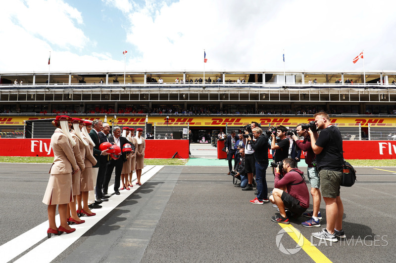 Sean Bratches, Managing Director of Commercial Operations, Formula One Group, Thierry Antinori, Executive Vice President and Chief Commercial Officer, Emirates Airlines, and Chase Carey, Chairman, Formula One, stand opposite photographers with flight attendants