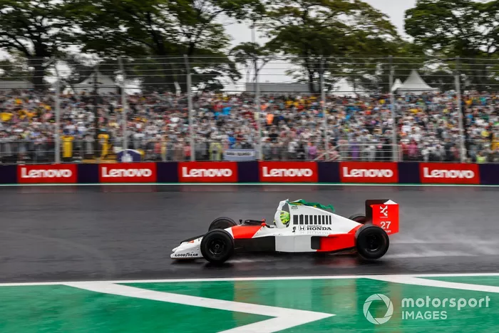 Lewis Hamilton conduce el McLaren MP4/5B de Ayrton Senna mientras sigue la bandera brasileña desde el cockpit