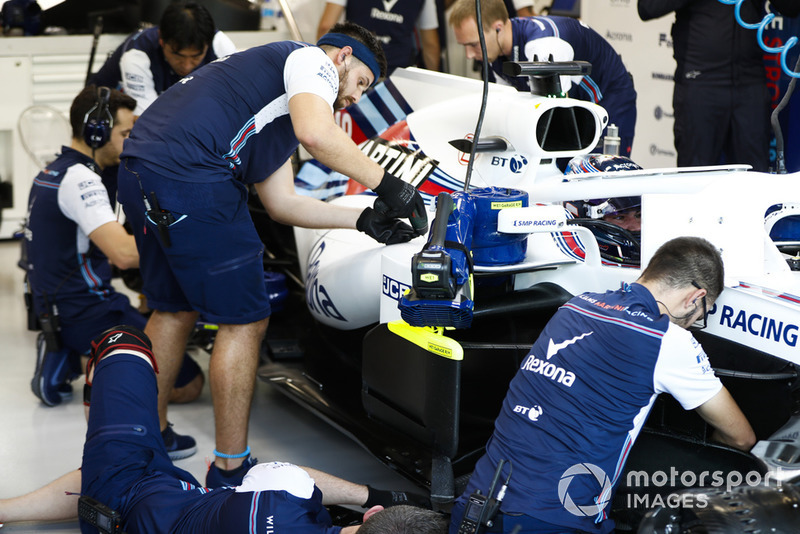 Engineers work on the car of Lance Stroll, Williams FW41, in the garage