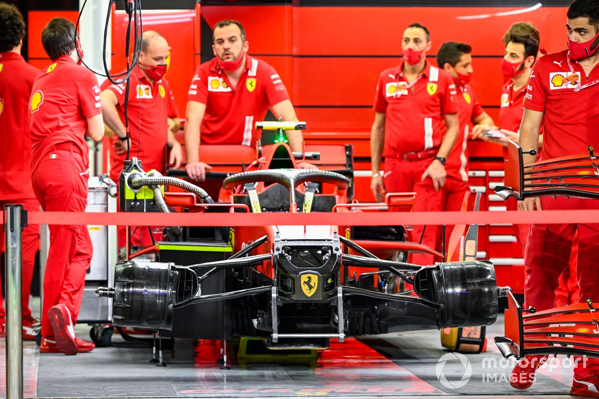 Ferrari mechanics in the garage with one of their cars