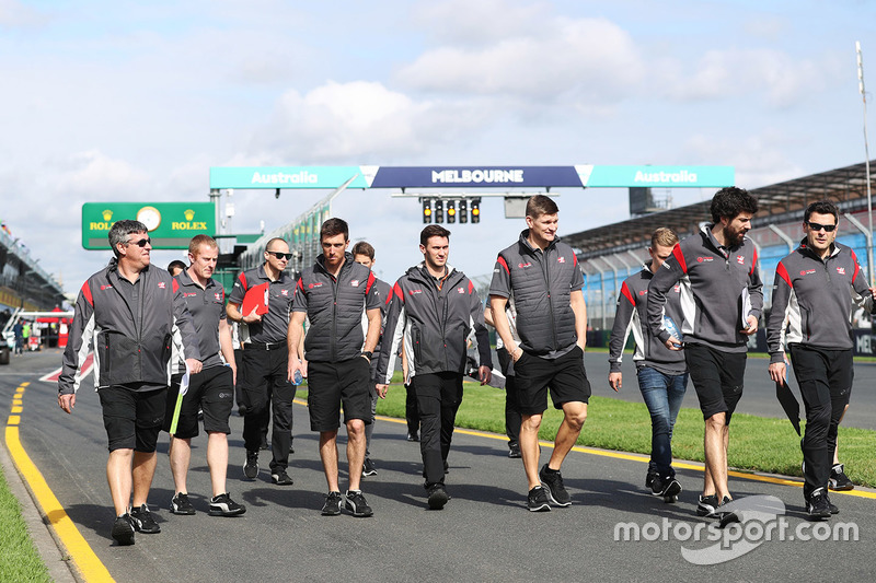 Romain Grosjean y Kevin Magnussen con miembros del equipo Haas caminan por el circuito