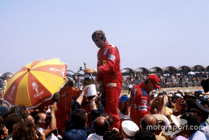 The podium (L to R): Emerson Fittipaldi, Fittipaldi, second (Obscured by umbrella); Carlos Reutemann, Ferrari, winner; Niki Lauda, Brabham, third