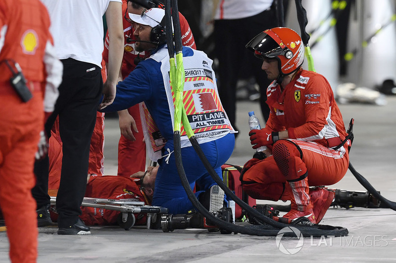 Un mecánico de Ferrari es atendido por médicos después de ser golpeado por el coche de Kimi Raikkonen, Ferrari SF71H durante una parada en boxes