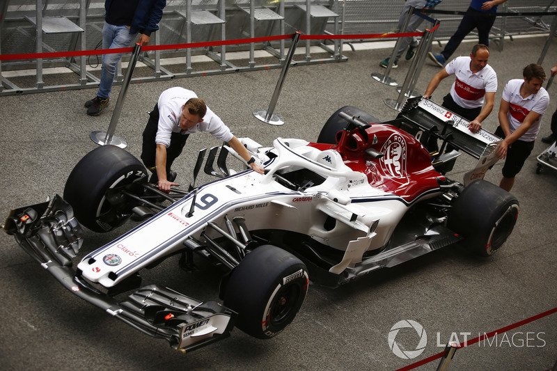 Los miembros del equipo Sauber conducen el Marcus Ericsson Sauber C37 en el carril de boxes