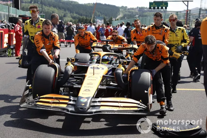 Mecánicos de McLaren empujan a Oscar Piastri, McLaren MCL38, a su puesto en la parrilla de salida 