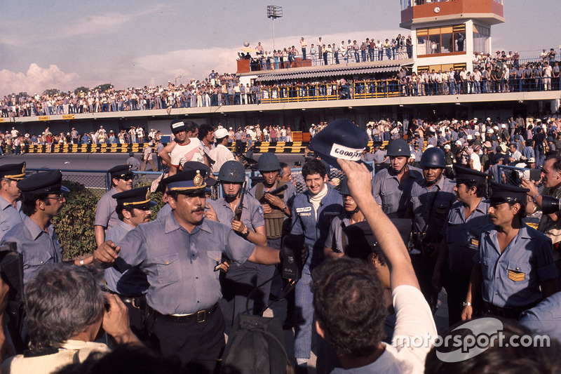 Le vainqueur Jody Scheckter, Wolf Ford entouré par le service de sécurité