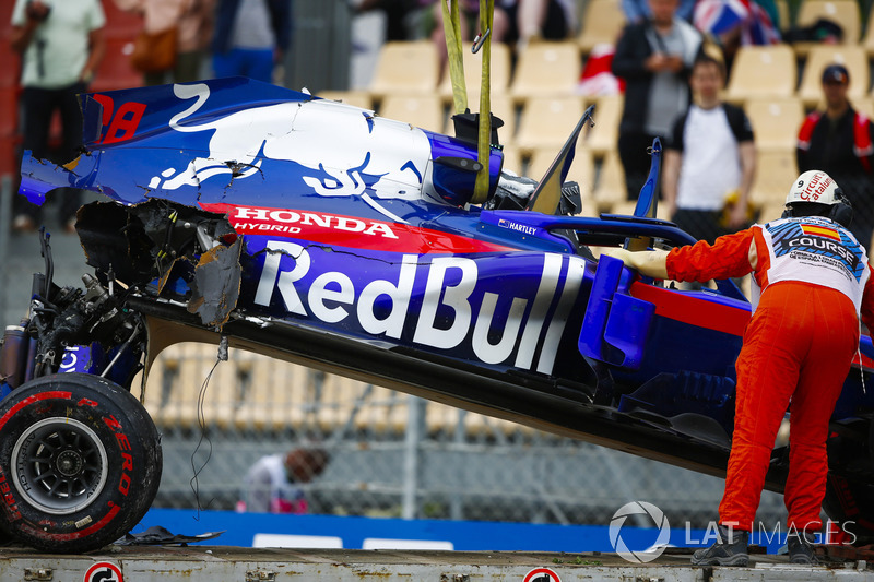 Marshals remove the damaged car of Brendon Hartley, Toro Rosso STR13, from the circuit as the gearbox hangs off the back