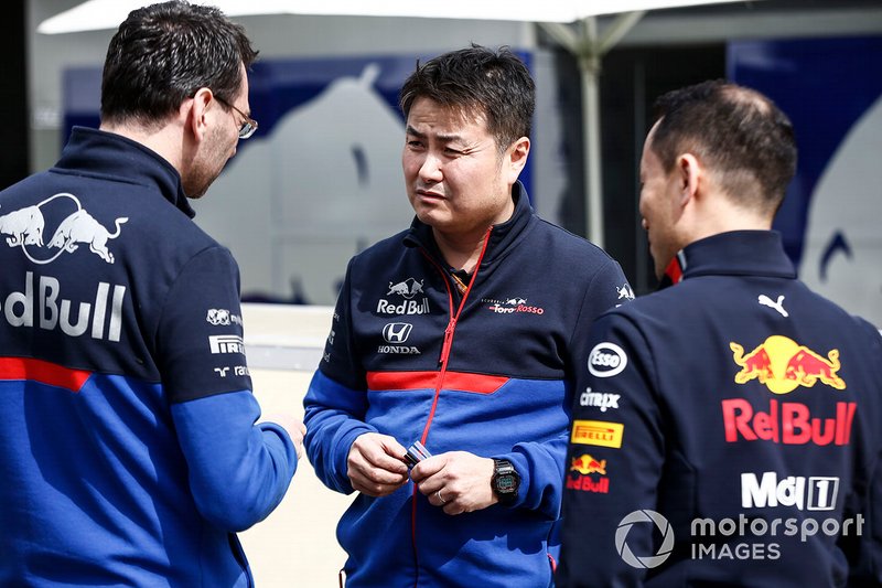 Red Bull Racing Honda and Toro Rosso Honda personnel talk in the pit lane