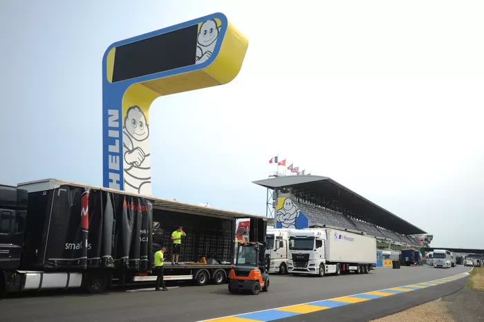 Trucks unload on the Start/Finish straight